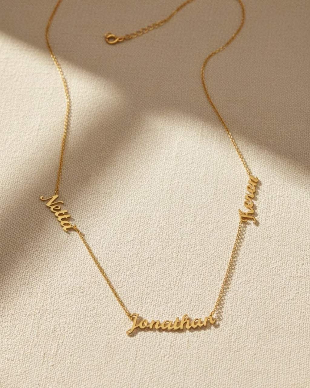 Gold necklace with the names Netta, Jonathan and Keren in script